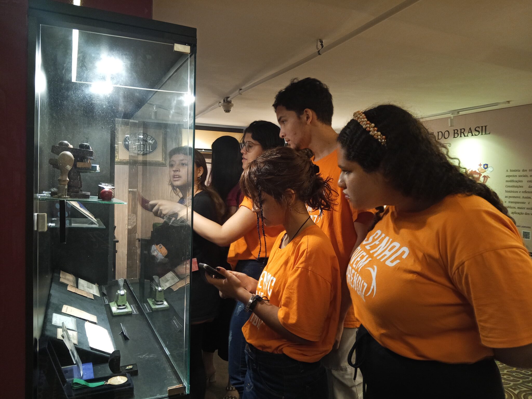 Visita, em 05 de dezembro, da turma de Jovens Aprendizes em Administração do Serviço Nacional de Aprendizagem Comercial (Senac). Esse encontro faz parte das atividades do  Programa de Educação Fiscal do Ceará (PEF-CE), que objetiva promover reflexões a respeito da relação entre cidadania e tributação e tornar conhecida a importância e diversidade das atividades desenvolvidas pela Secretaria da Fazenda do Ceará  (Sefaz-CE). Conhecendo a exposição Notas de Memórias, os estudantes foram convidados a refletir sobre a importância de valorizar os documentos   históricos do Fisco cearense, como forma de também preservar a história estado. Foto: Estudantes na exposição Notas de Memórias.