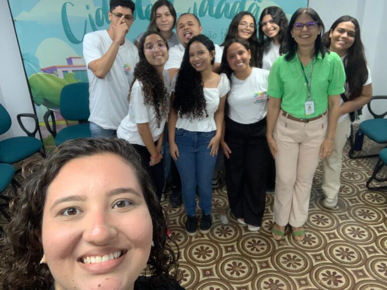 Foto de um grupo de jovens adultos de uma ONG, posando para uma selfie em uma visita.