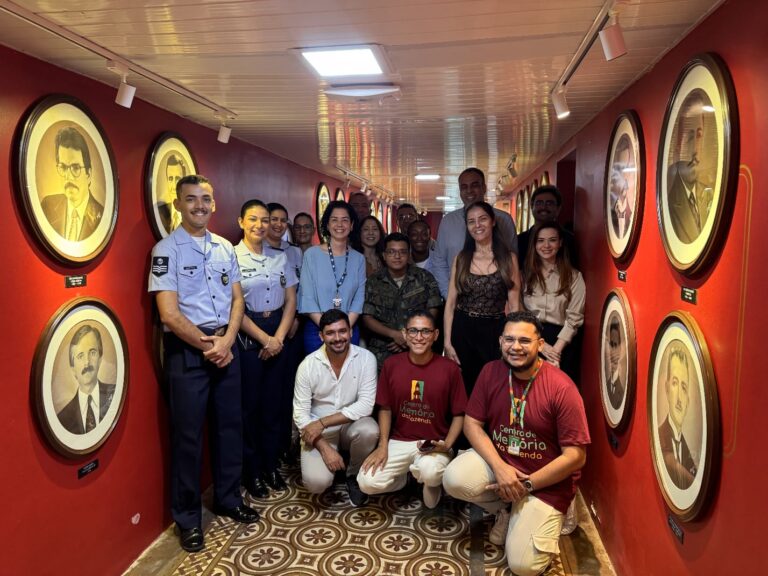 Grupo de representantes do Instituto Tecnológico de Aeronáutica e da Sefaz-CE posam em corredor do Centro de Memória da Fazenda, ladeado por retratos históricos emoldurados.