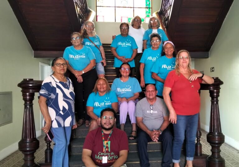Grupo de doze idosos e acompanhantes da segunda turma da Abemce, posando em uma escadaria de madeira durante uma visita em 13/11.