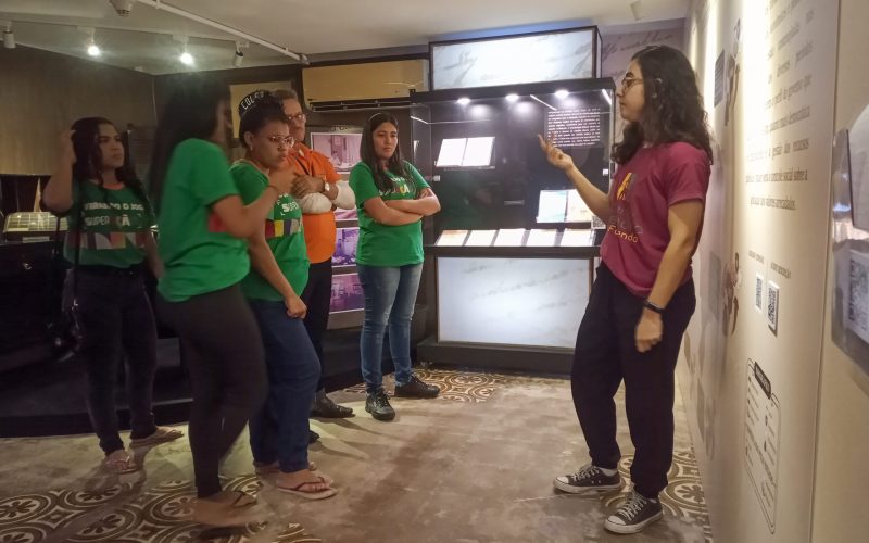 Visita do grupo de estudantes do Projeto Virando o Jogo, iniciativa do Governo do Estado do Ceará em parceria com o Serviço Nacional de Aprendizagem Comercial (Senac) Ceará, no dia 20 de Junho. As visitas fazem parte do projeto Escola no Fisco, idealizado pelo Programa de Educação Fiscal (PEF-CE), com o objetivo de convidar estudantes para conhecerem as atividades desenvolvidas pela Secretaria da Fazenda do Ceará (Sefaz-CE) e refletirem sobre tributação e cidadania. Foto: estudantes na exposição Notas de Memória do Centro de Memória da Secretaria da Fazenda do Ceará.