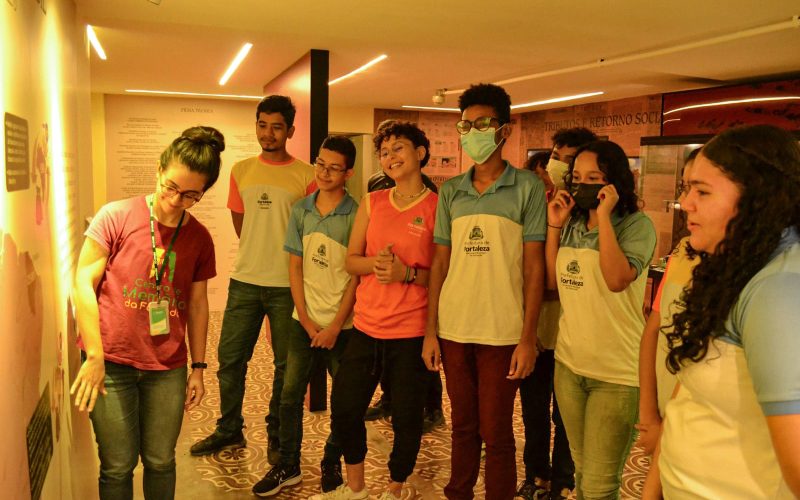 Visita do grupo de estudantes da Escola Municipal de Tempo Integral Guiomar da Silva Almeida, no dia 21 de Junho. As visitas fazem parte do projeto Escola no Fisco, idealizado pelo Programa de Educação Fiscal (PEF-CE), com o objetivo de convidar estudantes para conhecerem as atividades desenvolvidas pela Secretaria da Fazenda do Ceará (Sefaz-CE) e refletirem sobre tributação e cidadania. Foto: estudantes na exposição Notas de Memória do Centro de Memória da Secretaria da Fazenda do Ceará.