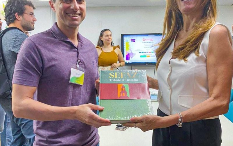 Sorteio do livro “Sefaz: tributo à história” como parte da visita ao Centro de Memória da Fazenda.
