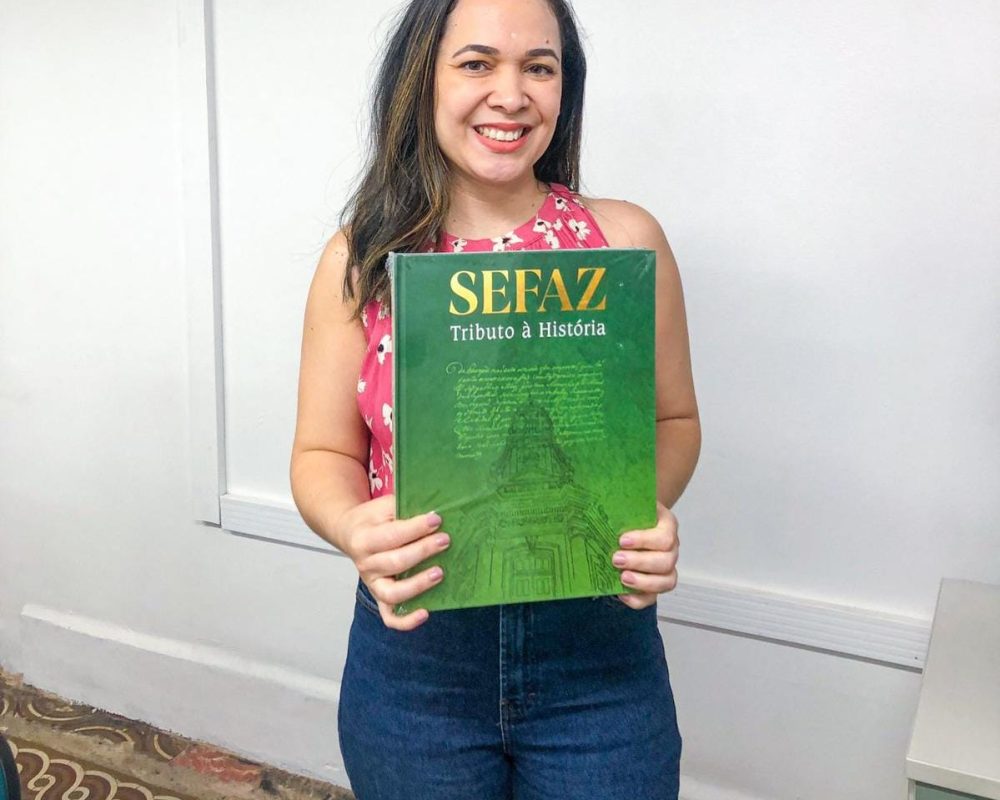 Sorteio do livro “Sefaz: tributo à história” como parte da visita ao Centro de Memória da Fazenda.