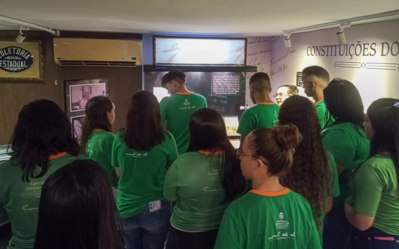 Visita do grupo de estudantes do Serviço Nacional de Aprendizagem Comercial (Senac) Ceará, no dia 30 de Maio. As visitas fazem parte do projeto Escola no Fisco, idealizado pelo Programa de Educação Fiscal (PEF-CE), com o objetivo de convidar estudantes para conhecerem as atividades desenvolvidas pela Secretaria da Fazenda do Ceará (Sefaz-CE) e refletirem sobre tributação e cidadania. Foto: estudantes na exposição “Notas de Memória” do Centro de Memória da Secretaria da Fazenda do Ceará.