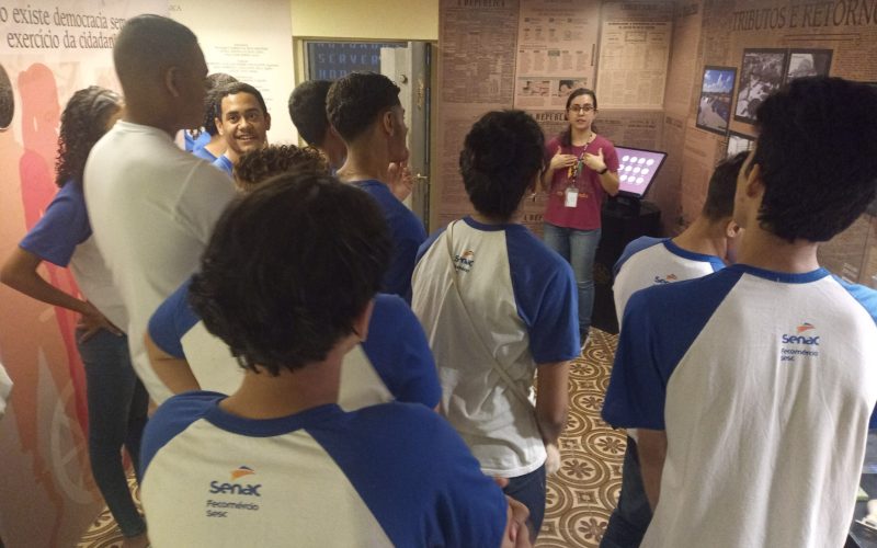Visita do grupo de estudantes do Serviço Nacional de Aprendizagem Comercial (Senac) Ceará, no dia 30 de Junho. As visitas fazem parte do projeto Escola no Fisco, idealizado pelo Programa de Educação Fiscal (PEF-CE), com o objetivo de convidar estudantes para conhecerem as atividades desenvolvidas pela Secretaria da Fazenda do Ceará (Sefaz-CE) e refletirem sobre tributação e cidadania. Foto: estudantes visitando a exposição Notas de Memória do Centro de Memória da Secretaria da Fazenda do Ceará.