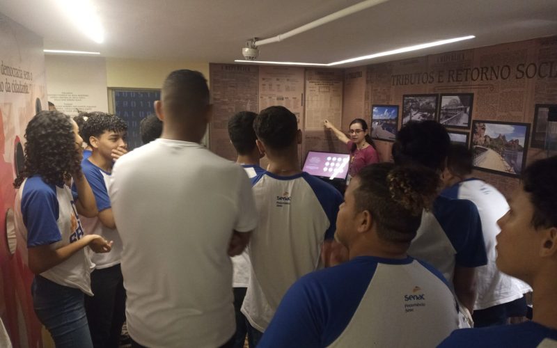 Visita do grupo de estudantes do Serviço Nacional de Aprendizagem Comercial (Senac) Ceará, no dia 30 de Junho. As visitas fazem parte do projeto Escola no Fisco, idealizado pelo Programa de Educação Fiscal (PEF-CE), com o objetivo de convidar estudantes para conhecerem as atividades desenvolvidas pela Secretaria da Fazenda do Ceará (Sefaz-CE) e refletirem sobre tributação e cidadania. Foto: estudantes visitando a exposição Notas de Memória do Centro de Memória da Secretaria da Fazenda do Ceará.