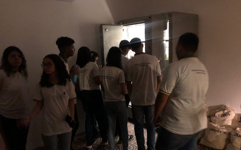 Visita do grupo de estudantes do curso profissionalizante de Contabilidade da Escola Estadual de Educação Profissional (EEEP) Joaquim Moreira de Sousa, no dia 21 de março. As visitas fazem parte do projeto Escola no Fisco, idealizado pelo Programa de Educação Fiscal (PEF-CE), com o objetivo de convidar estudantes para conhecerem as atividades desenvolvidas pela Secretaria da Fazenda do Ceará (Sefaz-CE) e refletirem sobre tributação e cidadania fiscal. Na foto: estudantes na exposição “Notas de Memórias” , momento da visitação na Sala-Cofre.