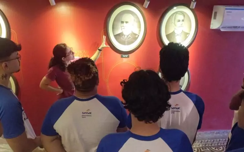 Visita do grupo de estudantes do Serviço Nacional de Aprendizagem Comercial (Senac) Ceará, no dia 30 de Junho. As visitas fazem parte do projeto Escola no Fisco, idealizado pelo Programa de Educação Fiscal (PEF-CE), com o objetivo de convidar estudantes para conhecerem as atividades desenvolvidas pela Secretaria da Fazenda do Ceará (Sefaz-CE) e refletirem sobre tributação e cidadania. Foto: estudantes visitando a exposição Galeria dos Secretários do Centro de Memória da Secretaria da Fazenda do Ceará.
