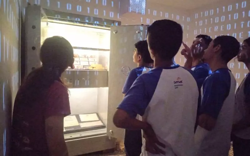 Visita do grupo de estudantes do Serviço Nacional de Aprendizagem Comercial (Senac) Ceará, no dia 30 de Junho. As visitas fazem parte do projeto Escola no Fisco, idealizado pelo Programa de Educação Fiscal (PEF-CE), com o objetivo de convidar estudantes para conhecerem as atividades desenvolvidas pela Secretaria da Fazenda do Ceará (Sefaz-CE) e refletirem sobre tributação e cidadania. Foto: estudantes visitando a exposição Notas de Memória do Centro de Memória da Secretaria da Fazenda do Ceará, no momento de visitação a Sala Cofre.