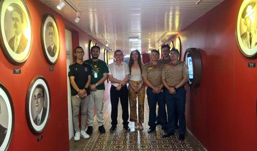 Representantes do Corpo de Bombeiros Militar do Estado do Ceará (CBMCE), a gestora do Centro de Memória da Fazenda (CM), Clarissa Barroso, e o historiador e educador do CM, Daniel Magalhães, em pé na Galeria dos Secretários do Centro de Memória da Fazenda do Ceará